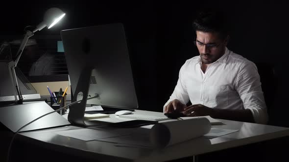 Asian businessman seriously working at night on internet with client in different time zone
