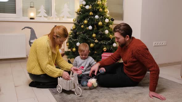 Happy Family Having Fun and Playing Together Near Christmas Tree alt
