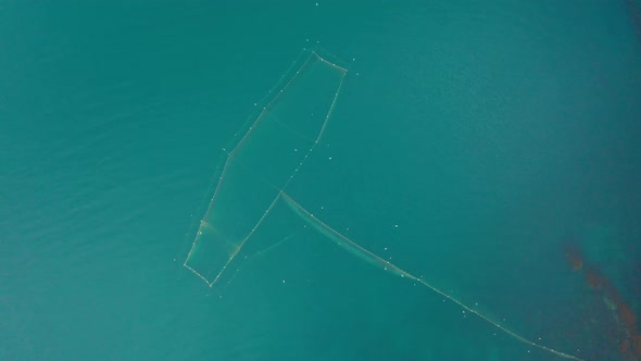 Drone flight above fishing nets in the sea water alt