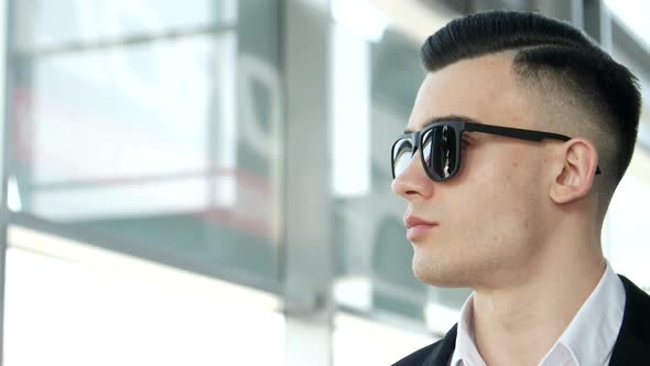 A smiling young man, looking into the interior of a new car alt