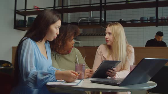 Busy Diverse Female Colleagues Sharing Business Ideas at Cafe alt