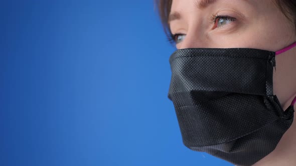Slow Motion: Woman Wearing Medical Face Mask, Looking Away at Home - Close Up