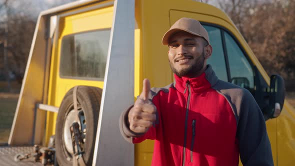 Young Indian Mechanic Wearing A Cap Smiling Making Thumbs Up Sign At The Camera alt