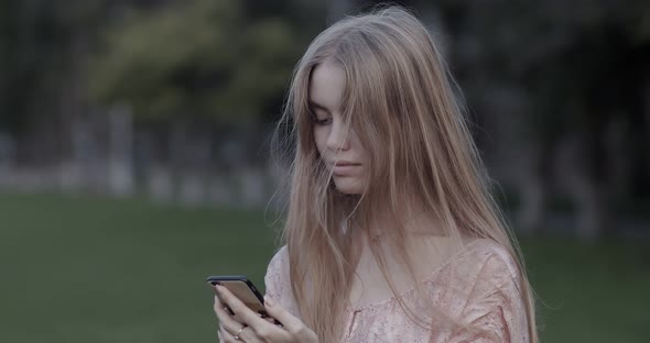 Beautiful young girl is looking at the phone