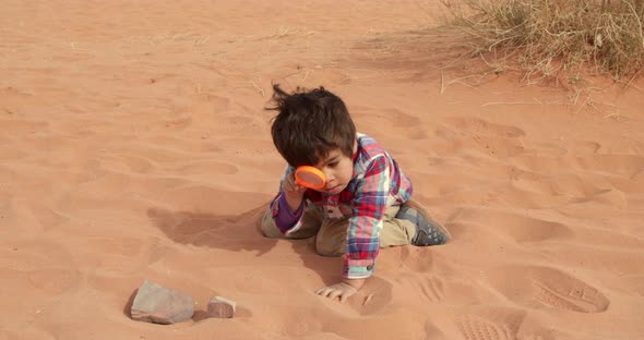 Boy playing in desert, Wadi Rum Desert, Aqaba Governorate, Jordan