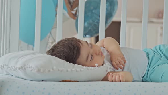 Baby Boy Sleeping In A White Children's Bed alt