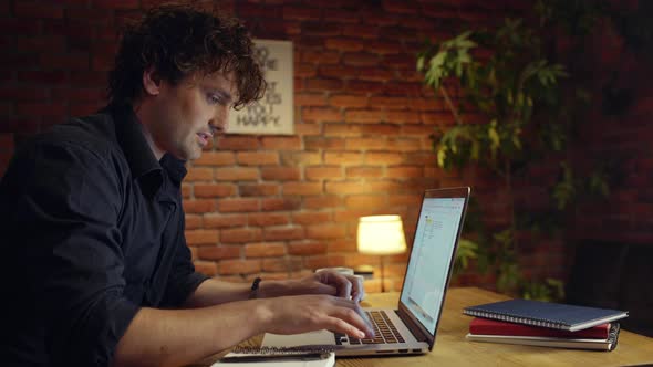 Young Successful Businessman Smiling Working in Office at Night alt
