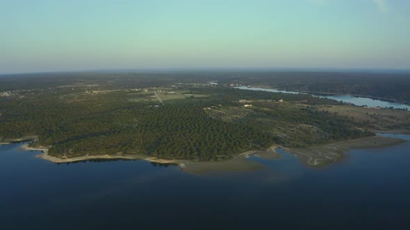 Aerial view of green rural landscape with huge dam at sunrise time, Alentejo, Europe alt