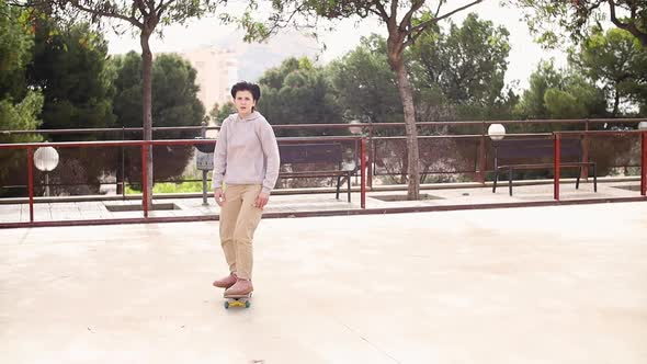 Teenage Girl Dressed in Hoodie Riding Skateboard