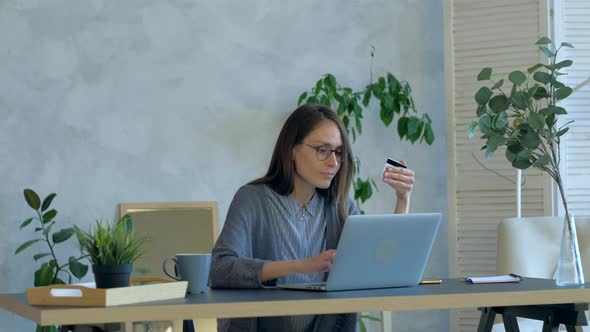 Female Buying Online Shopping By Card in Interior Using Notebook at Day Time alt