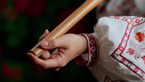 Hand of Woman Playing on Woodwind Wooden Flute  Ukrainian Telenka or Tylynka on Dark Background alt