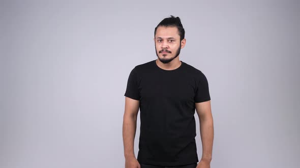 An angry Indian young adult saying NO and shaking his head alt