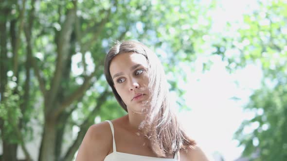 Pretty Young Brunette Female Long Disheveled Hair Wind Goes Away Green Trees alt