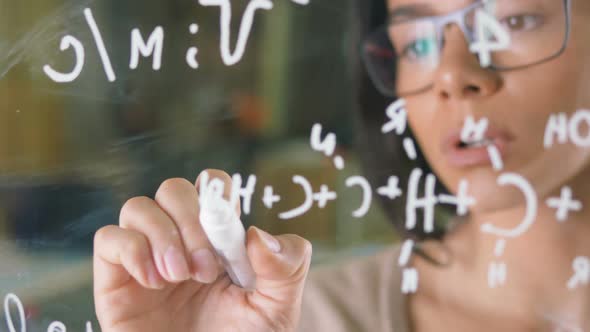 Young Attractive Female Office Worker Writing on Glass Whiteboard Close Up alt