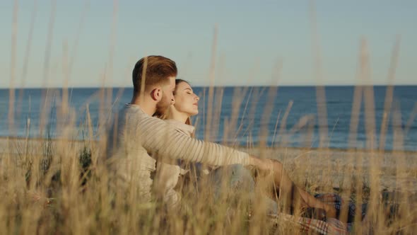 Guy hugs girl at the beach alt