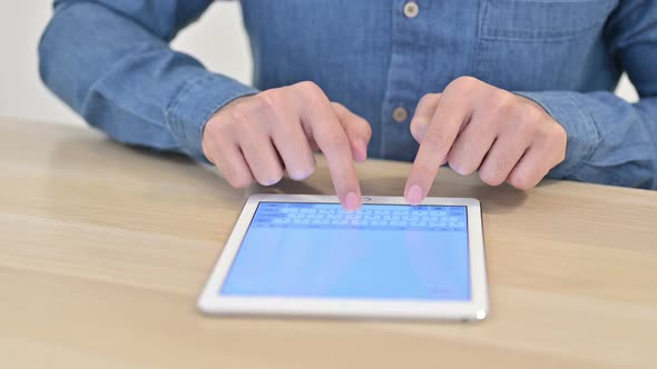 Close Up of Male Hand Typing on Tablet  alt