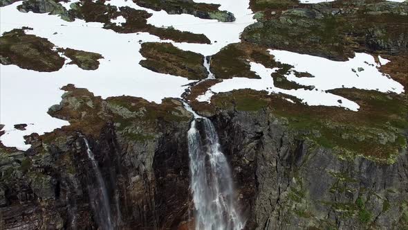 Breathtaking flight over tall waterfall in Norway, aerial footage