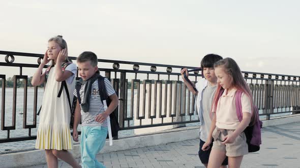 Schoolchildren, a Boys and a Girls, Go To School with Backpacks alt