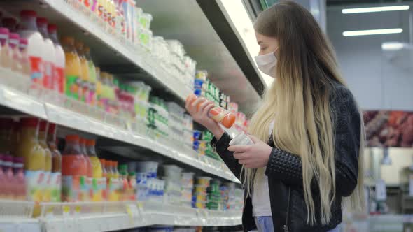 Young Lady in Medical Mask Buying Juice and Yogurt in Shopping Center alt