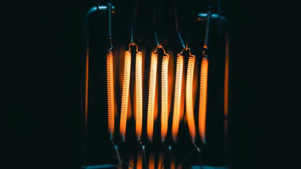 The Filament Incandescent Lamp Is Lighting And Moves On A Black Background