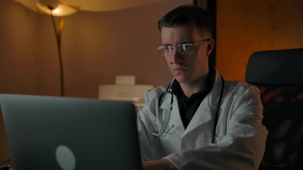 Serious Doctor Consulting Client Online Via Laptop and Looking at Camera alt