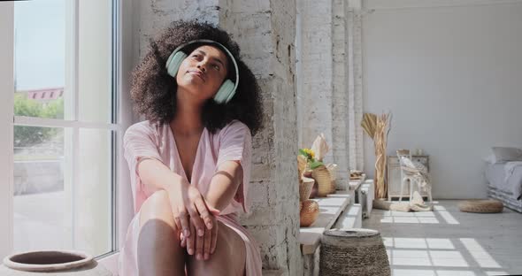 A Lovely Mixedrace Woman Listens to Calming Music on Her Phone and is Charmed By the Positive alt