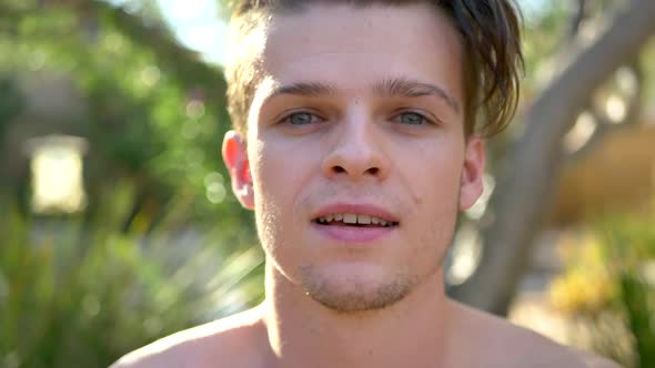 A fit young attractive white man smiling happily and closing his eyes while exhaling his breath in m alt