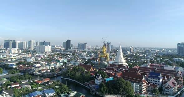 Big Golden Buddha sitting in a city landscape, Wat Paknam under construction. DRONE AERIAL alt