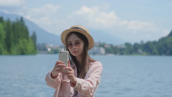 Asian Woman is Photographing Herself By Cell Phone in Nature in Slovenia alt