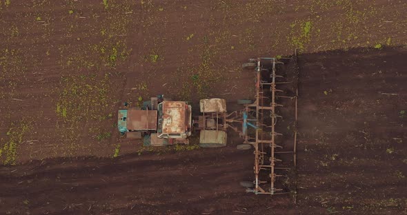 Tractor is Plowing Soil on Agricultural Field in Seeding Season View From Drone  Prores