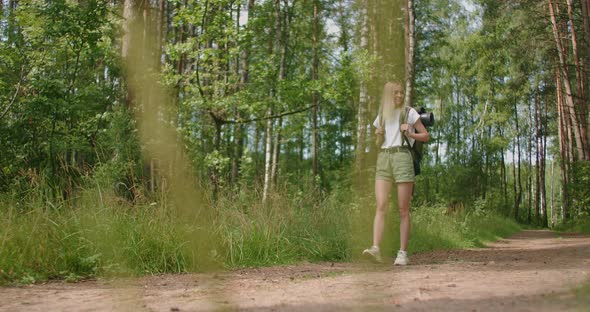 Adult Woman Wearing Shorts and T-shirt Hikes Through Woods. Young Lady Hiking alt