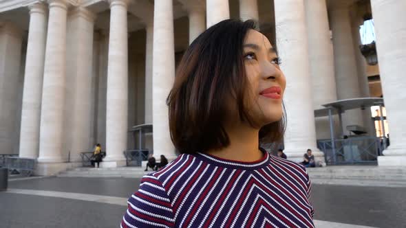 smiling chinese woman contemplating Saint Peter square- slow motion alt