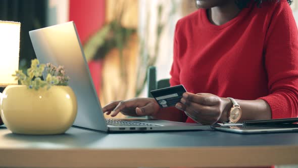 African-American Woman Is Using a Card for Online Shopping alt