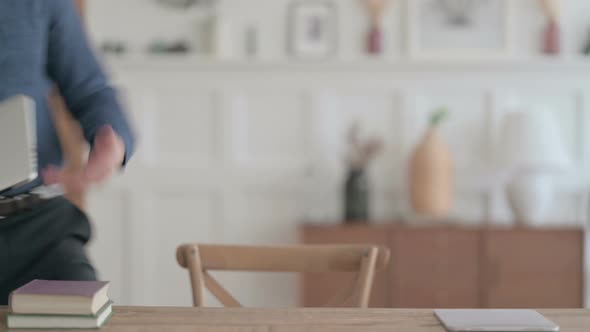 Man Coming Back Opening Laptop in Office alt