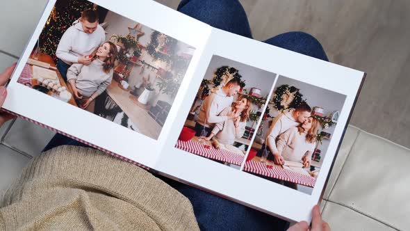 Woman Flips Through the Pages of Photobook From a New Year's Family Photo Shoot alt