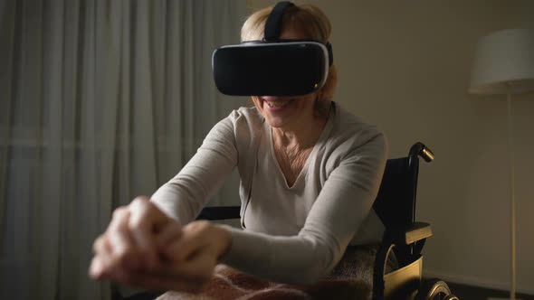 Excited Senior Lady in Wheelchair Having Fun in Modern Virtual Reality Headset alt