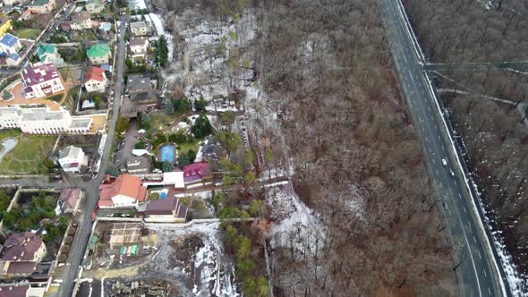 Fly above city street, residential area in winter