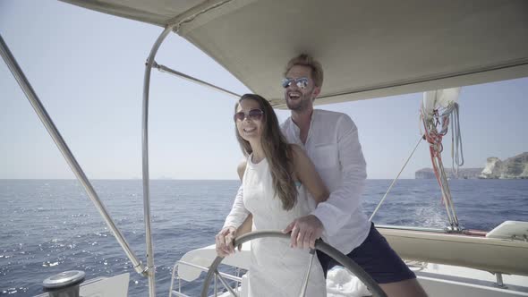 Couple at Steering Wheel of Boat alt