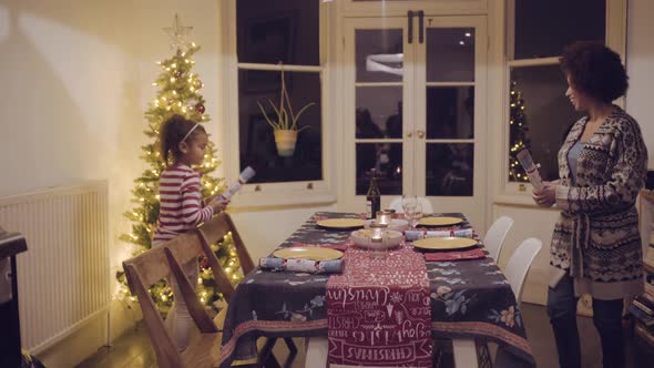 Mother and daughter prepare Christmas dinner table