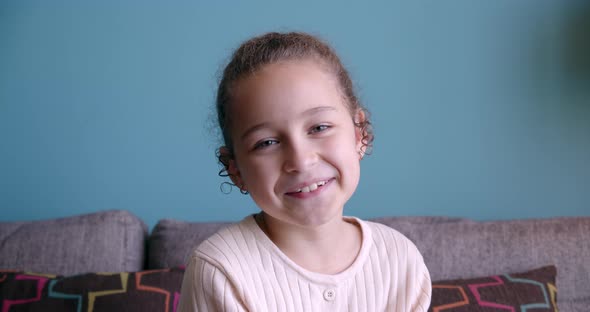 Portrait Funny Little Girl Smiling Child Looking at Camera are Sitting on the Couch at Home Cute Kid alt