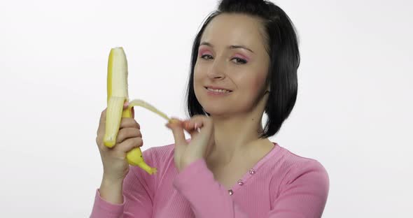 Young Woman Eating Banana and Says Yum. Girl Takes First Bite and Say Wanna Bite alt
