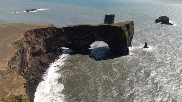 Lava arch at Dyrholaey peninsula next to Reynisfjara beach in Iceland alt