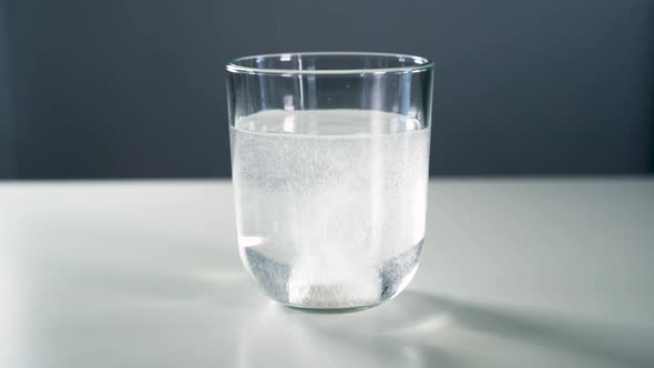 Effervescent tablet dropped into a glass of water 4K alt