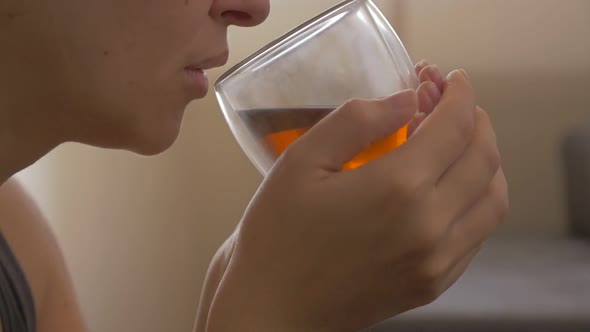 Woman holding hot cup in hands and drinks tea 1080p HD video - Drinking tea from glass cup 1920X1080 alt