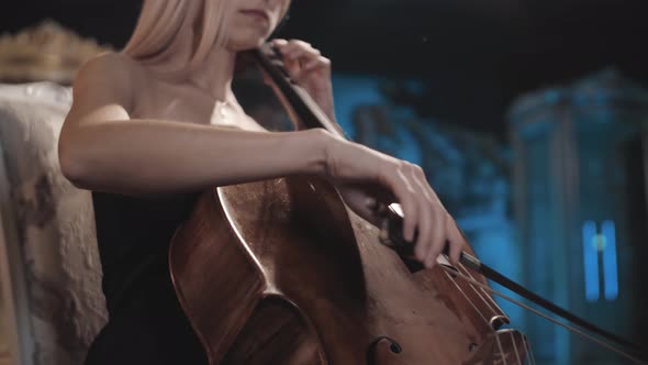 Blonde in a beautiful dress plays the cello. Cellist. Close Up