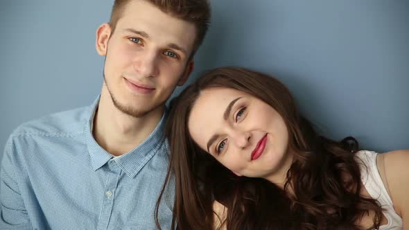 Young Couple in Love Sitting at Home By the Blue Wall