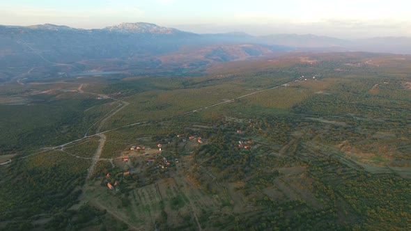 Aerial view of remote village in green valley alt