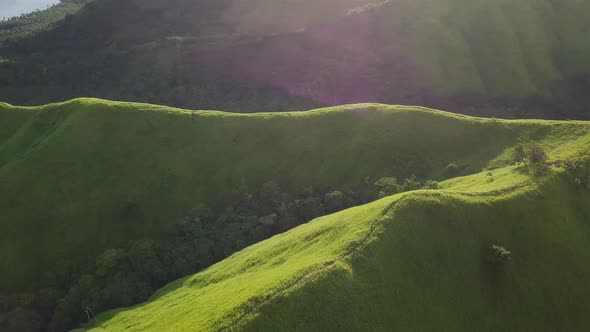 Flight Over a Green Grassy Rocky Hills