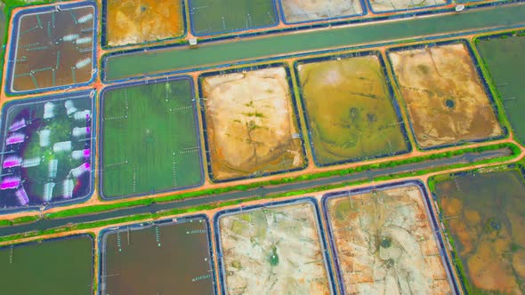 An aerial view over a drone flying over a large shrimp farm alt