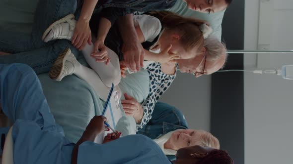 Vertical Video Medical Assistant Talking About Diagnosis with Woman in Visit alt